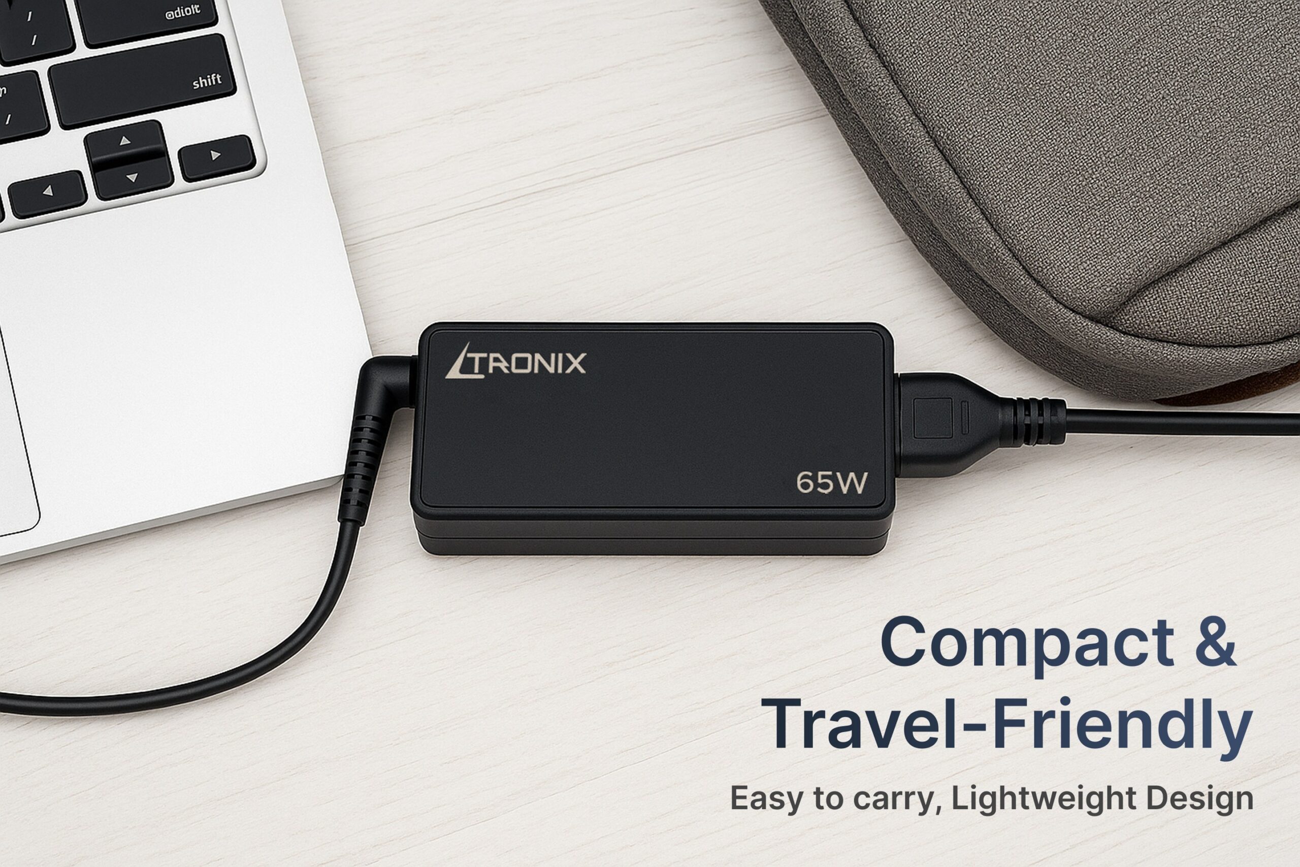 Ltronix 65W USB-C Laptop Charger, compact and travel-friendly design, shown connected to a silver laptop on a desk.